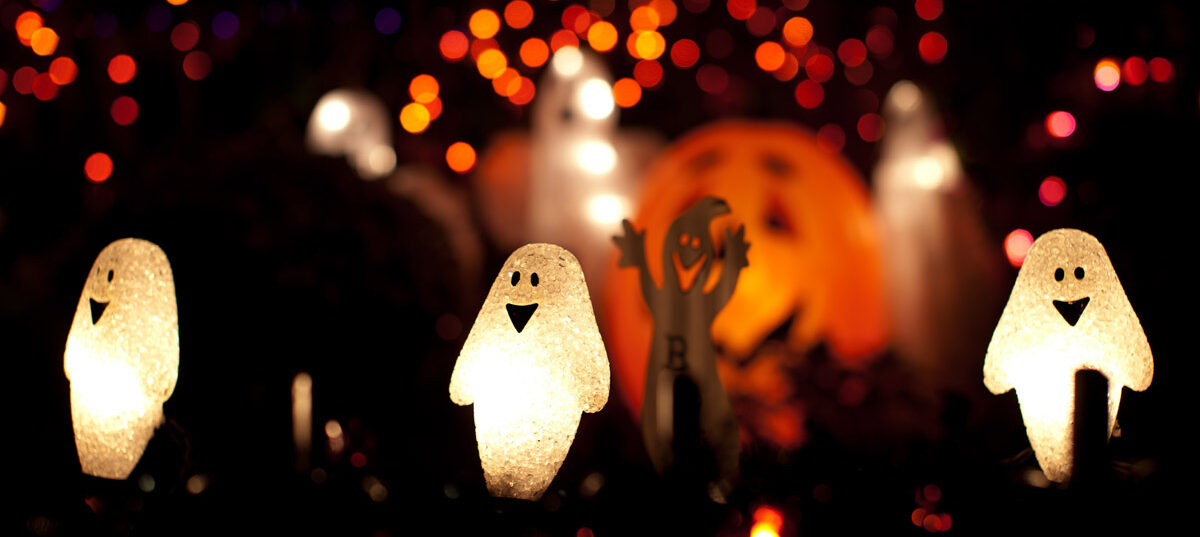 Assorted Halloween decorations lit up at night.