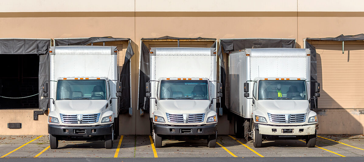 Delivery trucks parked at a shipping bay.