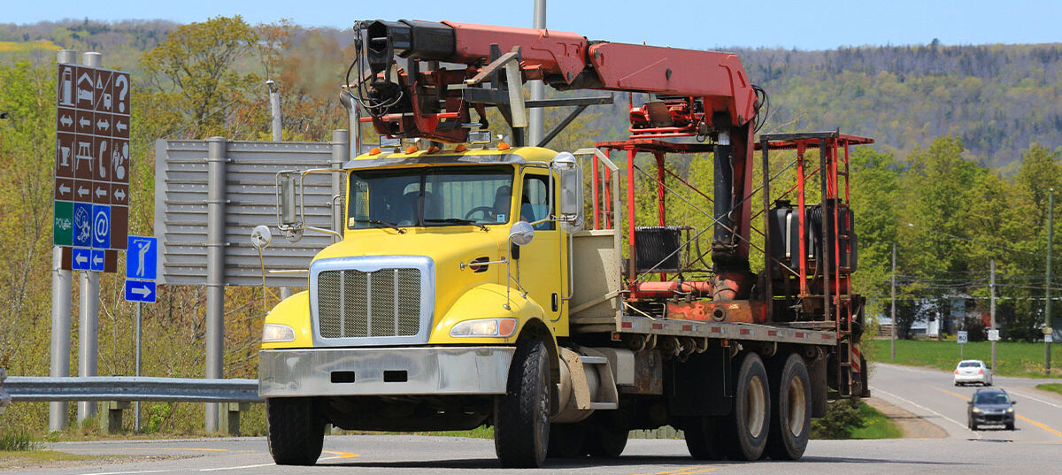 Large commercial vehicle with attached mechanical arm - insuring attached machinery