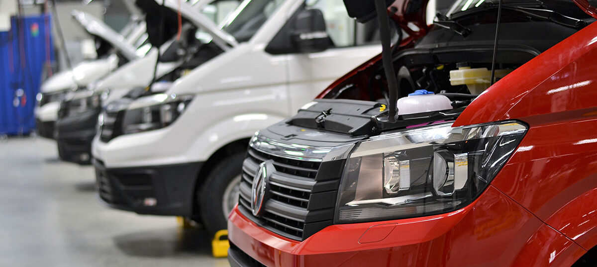 Row of fleet vans in an auto body garage