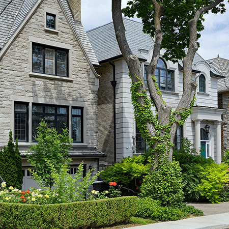 A grey brick home with a well-maintained garden.