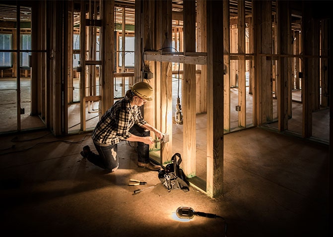 A home builder works on the frame of a new build home.