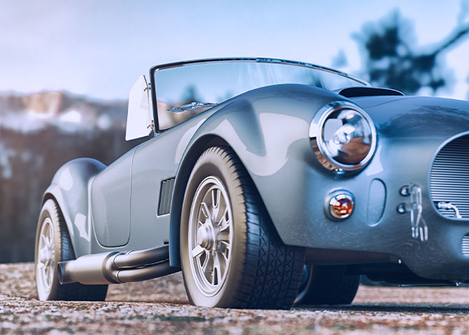 Blue classic car parked on gravel.