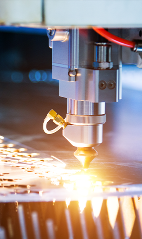 Laser cutting metal sheet with sparks flying.