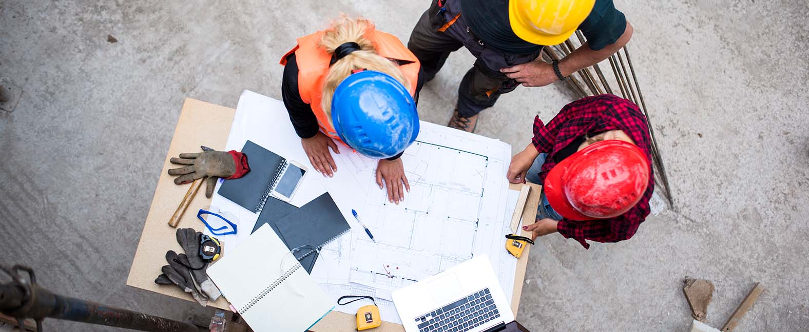 Contractors around a table discussing the layout of a home.