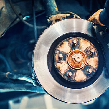 Change the old drive to the Brand new brake disc on car in a garage. Auto mechanic repairing .