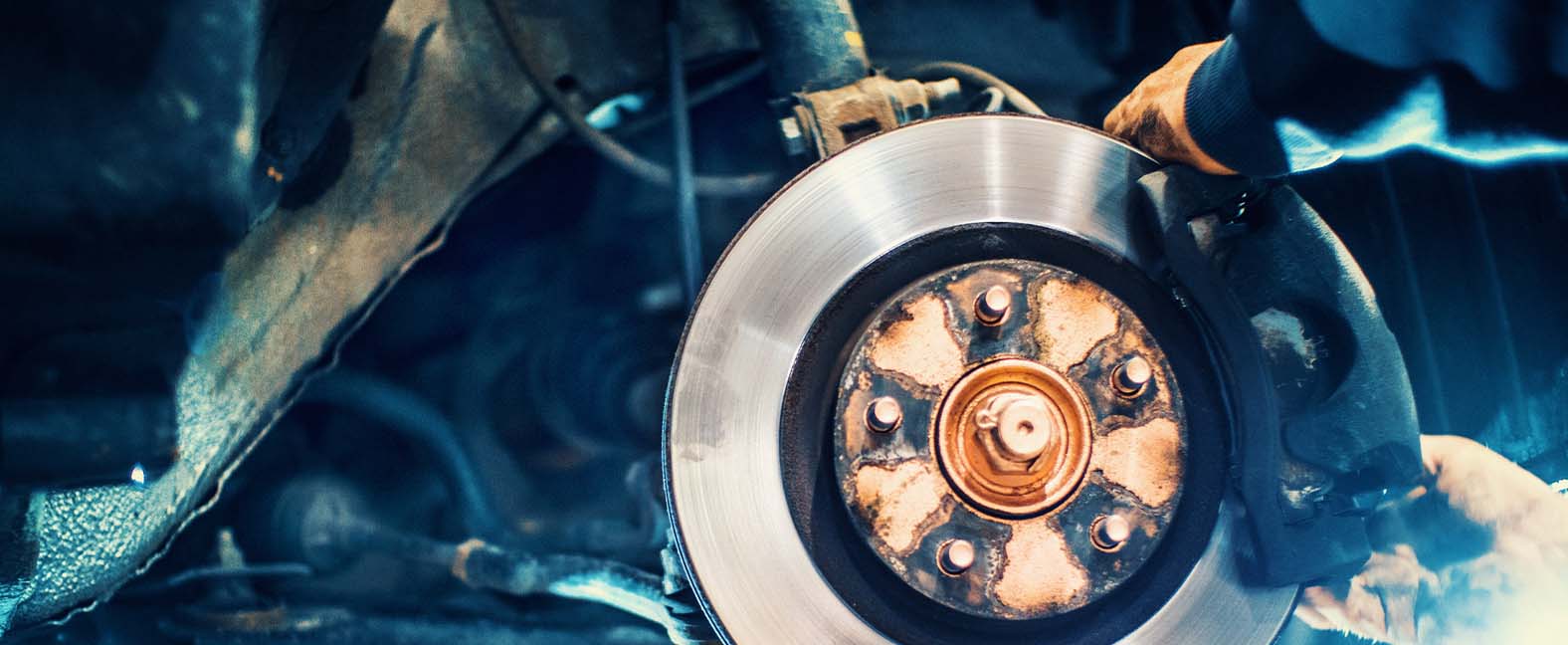 Change the old drive to the Brand new brake disc on car in a garage. Auto mechanic repairing .