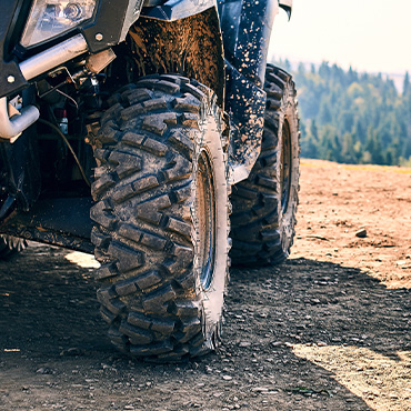 Close-up of an ATV tire covered in mud.